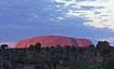 Ayers Rock (Uluru) photographed from a distance in sunset lighting