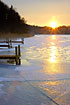 Sunset over frozen lake with boat bridge