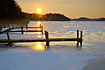 Sunset over frozen lake with boat bridge