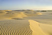 The morning sun hitting the large sand dunes - a desert landscape