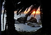 The sun rises over the sea seen through palm trees