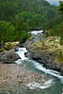 The Rauma River is rushing through forest and rocks in the rain