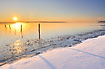 Winter sun and mist at the snow covered coast at Lillblt