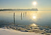Winter sun and mist at the snow covered coast at Lilleblt