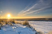 The sun rises above the snow covered dunes this winters morning