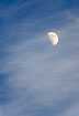 Half moon on blue sky with clouds