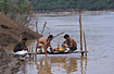 Local cambodians cleaning a roasted dog in the Mekong River