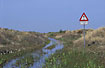 Flooded road with a sign saying impassable road in danish