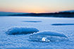 Ice lumps on a frozen lake at sunrise