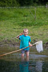 Kid catching pond insects
