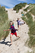 Kids playing in sand dunes in Rbjerg Mile near Skagen, Denmark.