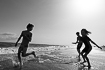Black and white image of kids playing on a beach