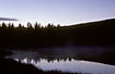 Evening atmosphere after sunset at a pond in a norwegian mountainside