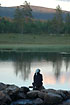 Woman enjoying the sunset at a mountain lake
