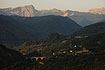 A few houses and a bridge in the foreground, the Apuan Alps in the background