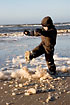 Boy playing on the beach in foam from the algae - Phaeocystis