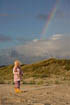 Girl on the beach with a rainbow above